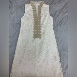 White lace dress with gold braiding on the front plaque